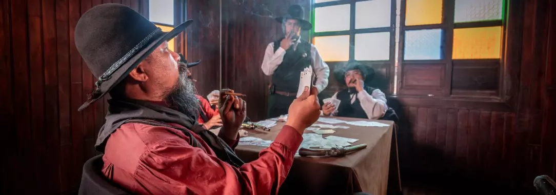 a picture of cowboys in the old Wild West playing poker in a smoke-filled saloon