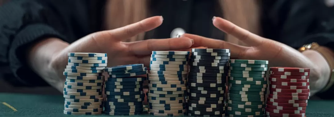 a young woman preparing to push a large stack of poker chips all in