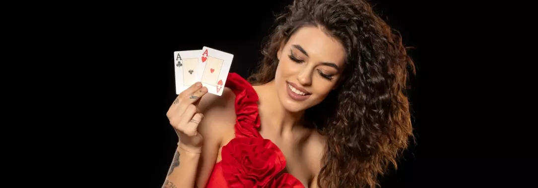 smiling pretty young female poker player showing that her hole cards are a pair of aces