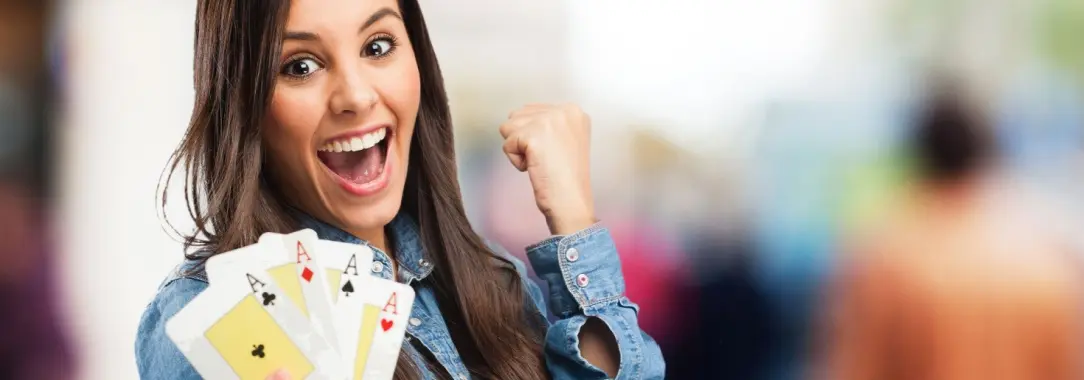 ecstatic pretty woman with long brown hair showing four aces