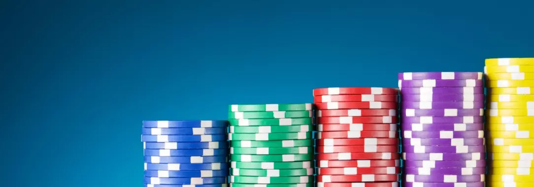 A close-up image of colorful stacks of poker chips on a blue background